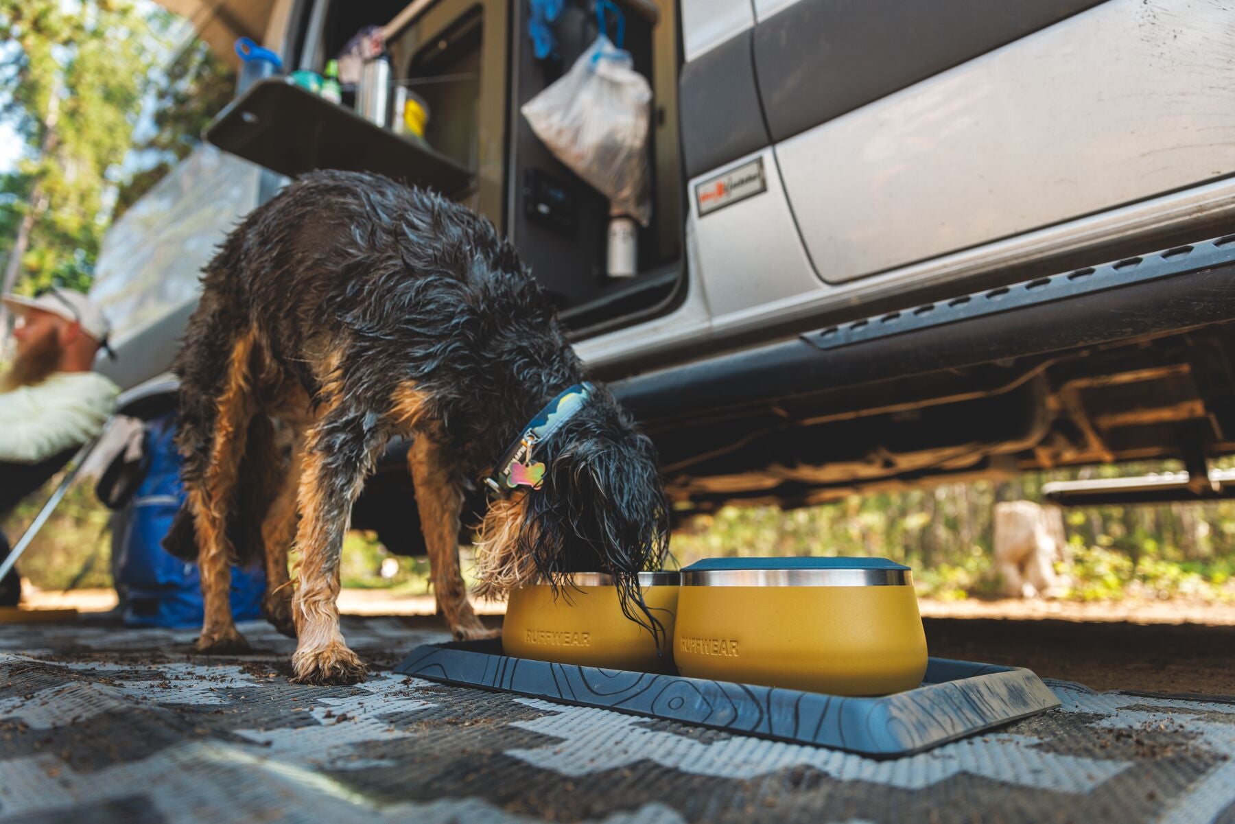 A dog chows down at their Basecamp™ Bowl and Mat setup.