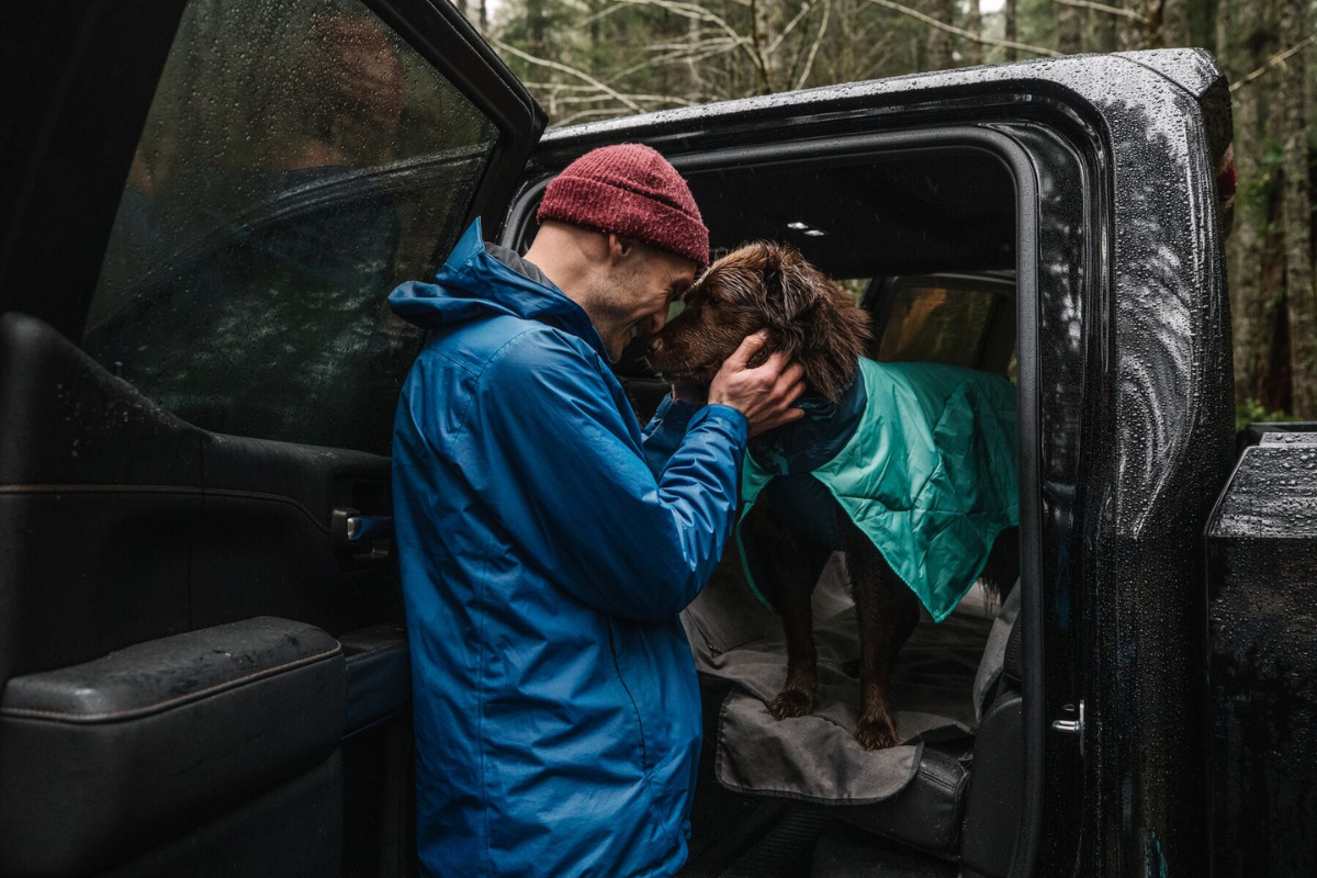 Man petting his dog wearing the Dirtbag™ Dog Towel.