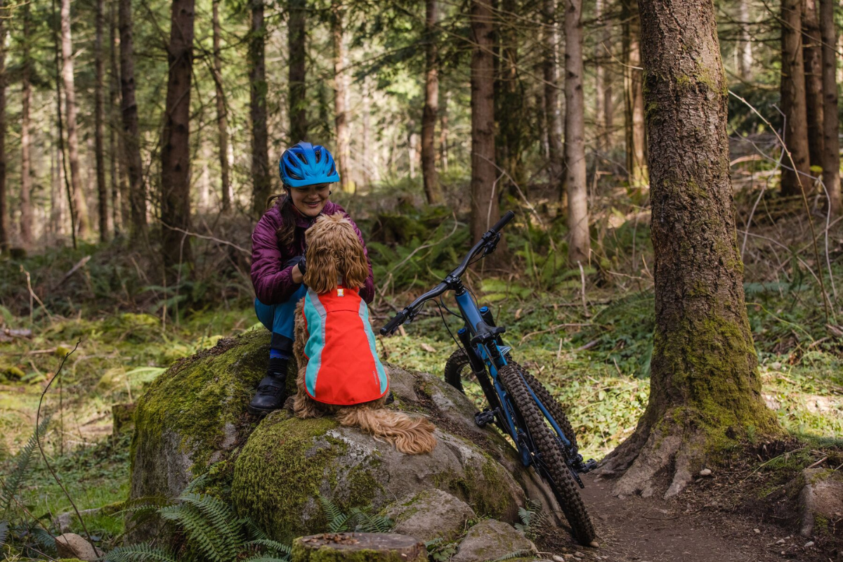 Woman biking with her dog in cold weather.